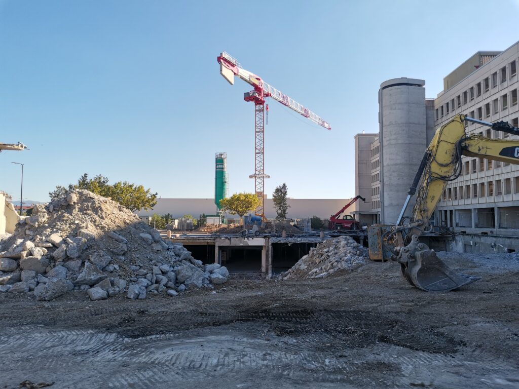 Travaux de gros œuvre et terrassement du site – Le perchoir paysage Phase de démolition et de terrassement avec grue à tour et pelleteuse sur le chantier de la MDSA